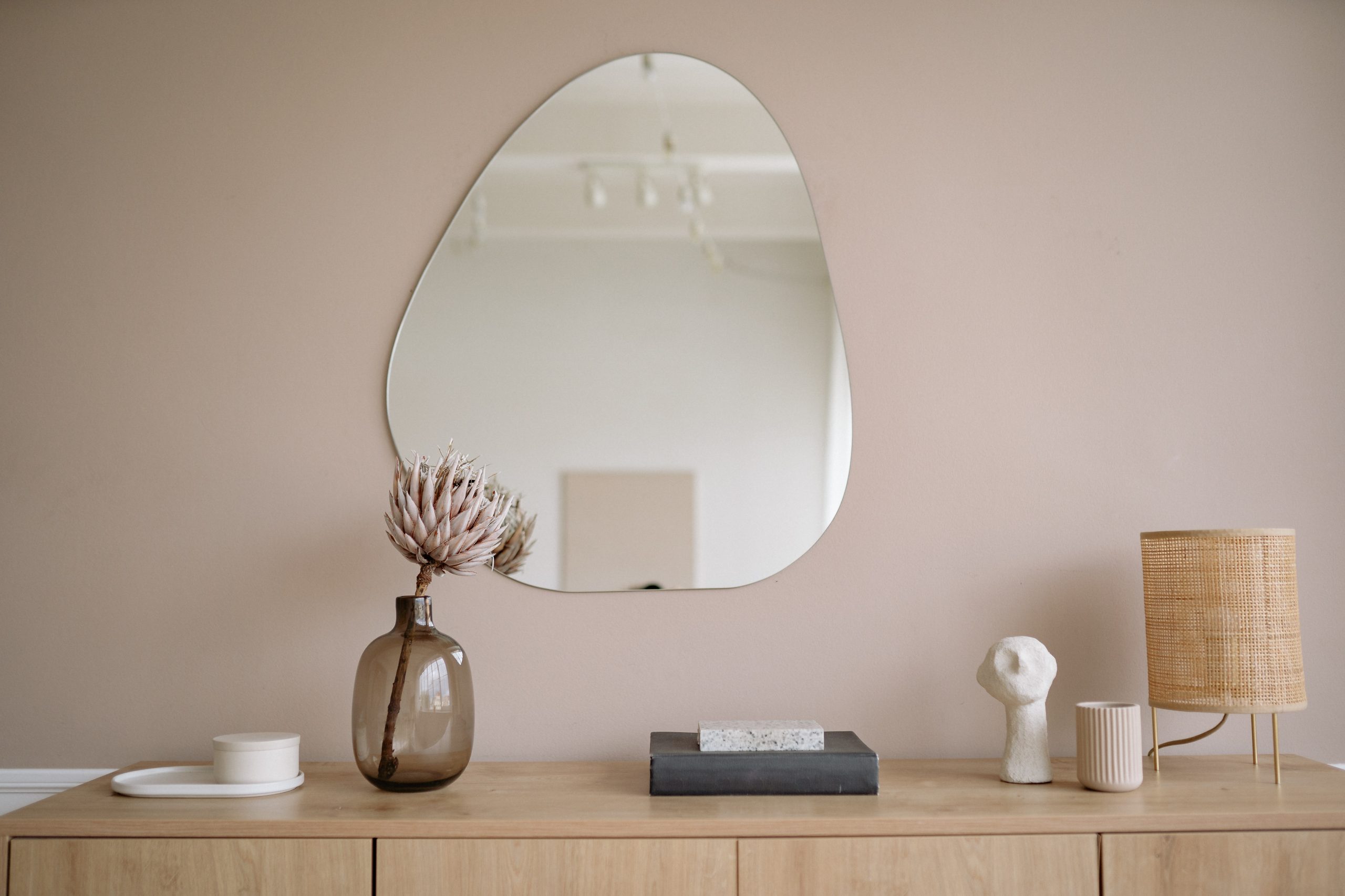 A cabinet with decorations on it and a mirror on the wall